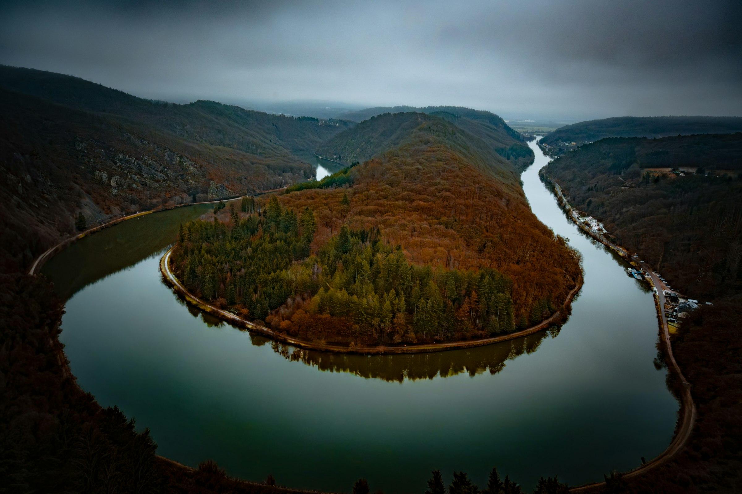 A river bending in a wide loop through dense forest, seen from above